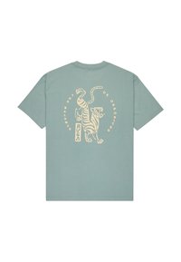 Mintgroene katoenen T-shirt met een grafisch ontwerp van twee tijgers op de rug, met de tekst "DE BALANS VAN TEGENSTELLEN" in crèmekleur.