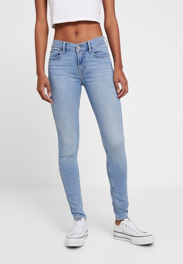 Jean skinny bleu clair en denim, avec un design classique à cinq poches, des passants de ceinture et une texture lisse avec un léger dégradé.