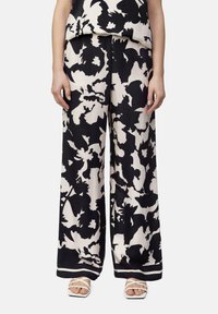 Weite Hosen im schwarz-cremefarbenen Blumenmuster, hergestellt aus einem glatten Material. Mit einem kontrastierenden Bund und geradem Schnitt.