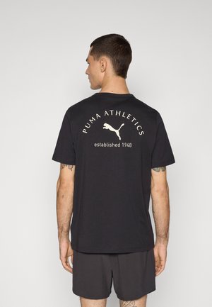 Zwarte katoenen t-shirt met een ronde hals, korte mouwen en een grote witte PUMA Athletics grafiek op de achterkant met de tekst 1948 opgericht.