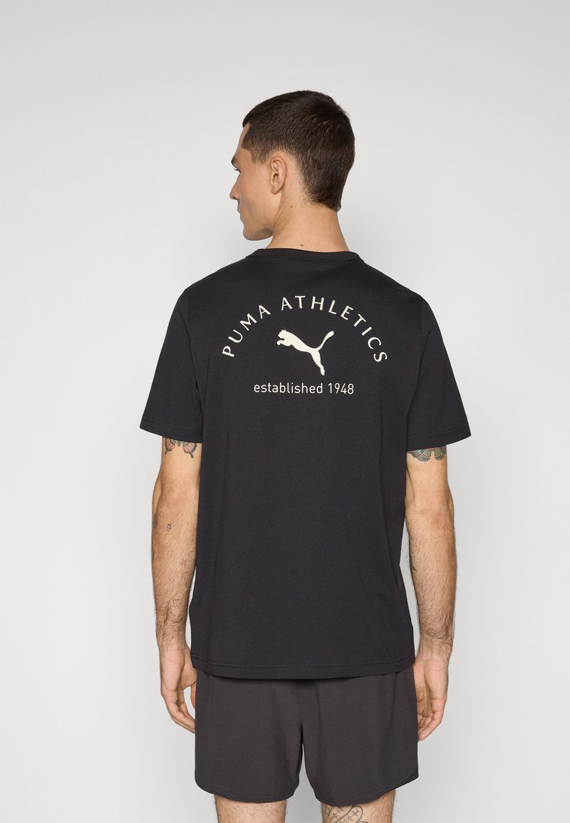 Sort bomulds t-shirt med rund halsudskæring, korte ærmer og et stort hvidt PUMA Athletics grafik på ryggen med teksten etableret 1948.