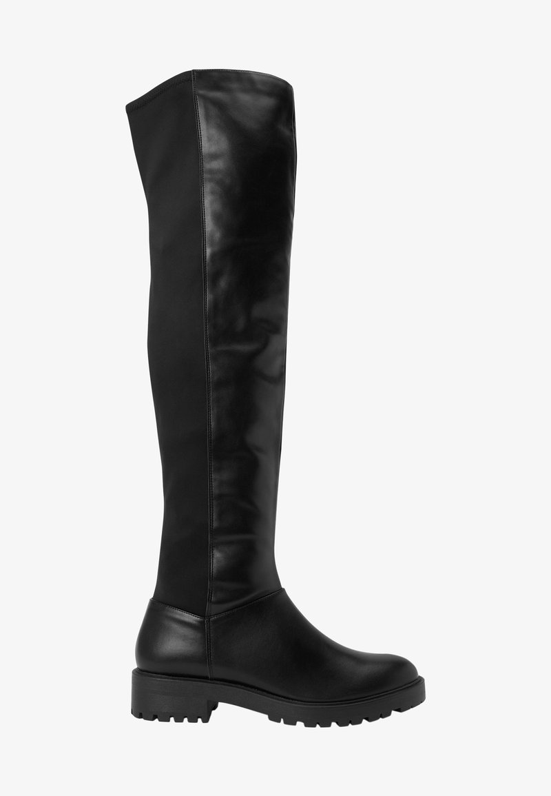 Botte haute en cuir noir avec semelle plate et épaisse et finition lisse, dépassant le genou, vue de profil sur fond blanc.