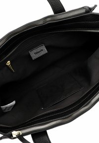 Das Innere einer schwarzen Lederhandtasche zeigt ein großes Hauptfach, eine mit Reißverschluss verschlossene Innentasche und ein eingenähtes Stoffetikett.