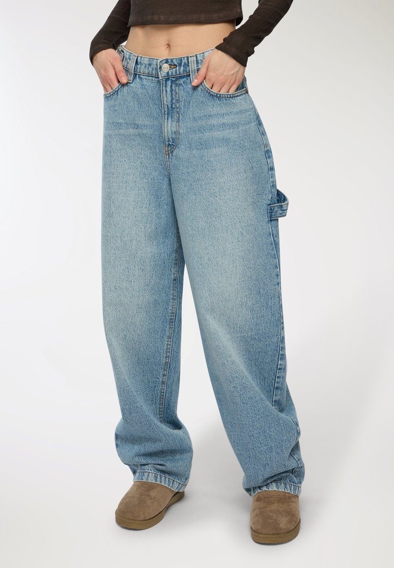 Jeans larghi di colore blu chiaro in denim, con vita alta, tasche anteriori e una tasca cargo sul lato.