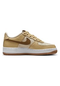 Basket basse Nike beige et marron clair avec logo Swoosh marron, semelle intermédiaire blanche et semelle extérieure en gomme, vue du côté extérieur.