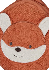 Terracotta fox face blanket with soft texture, cream accents for ears and snout, embroidered eyes and smile, rounded shape.