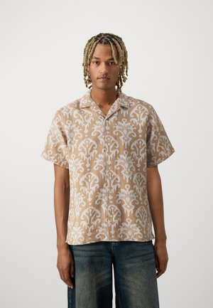 Camicia a maniche corte con bottoni in beige e bianco con un motivo floreale vorticoso, realizzata in tessuto leggero; vestibilità ampia e design del colletto.