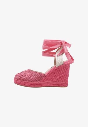 Zapato espadrille de cuña rosa con patrón floral bordado, tacón trenzado y cintas para atar alrededor del tobillo en forma de lazo.