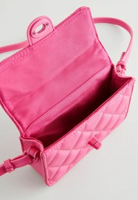 Rosa quiltad handväska i konstläder med en slät insida, som har en övre tryckknappsöppning och en avtagbar rem. Insidan är fodrad med matchande rosa tyg.