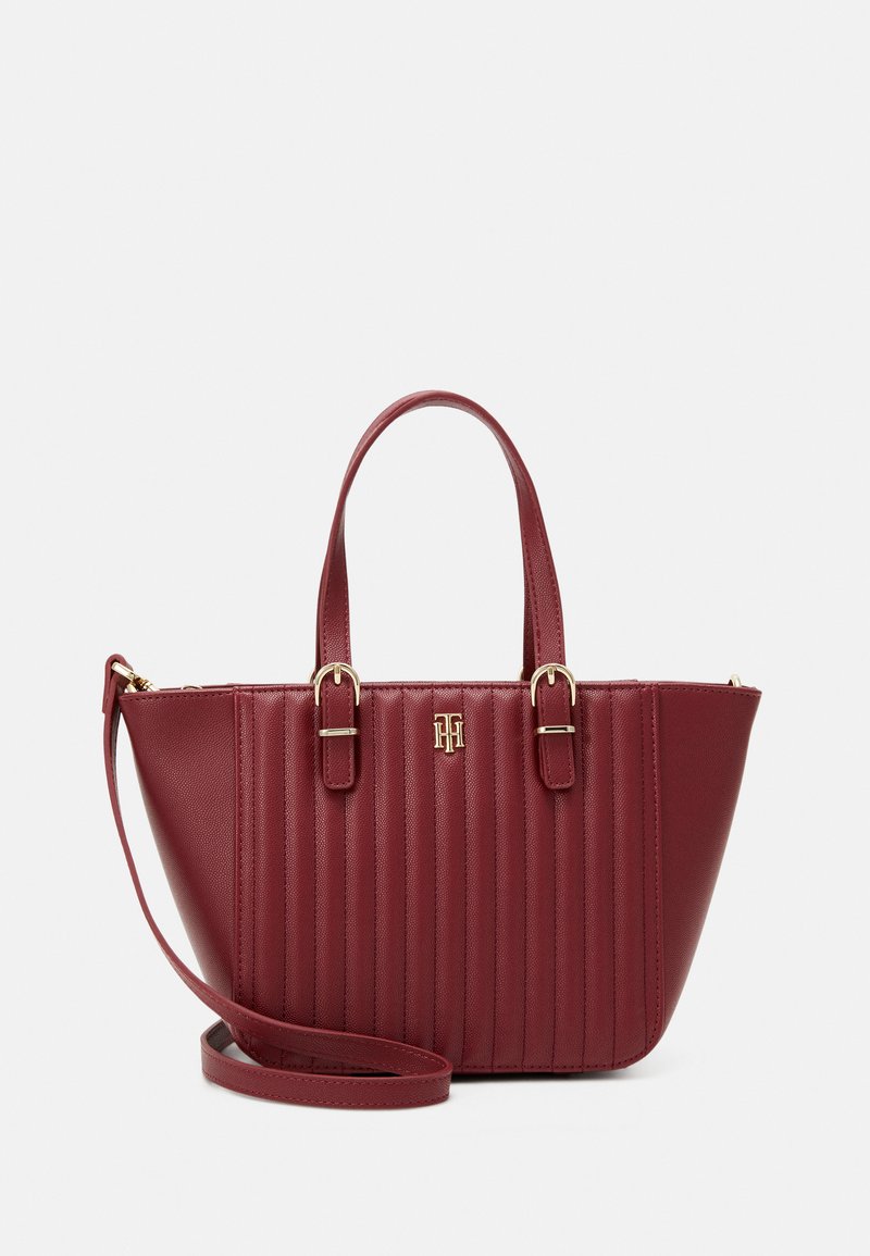 Rote Kunstleder-Handtasche mit vertikal geripptem Design, goldenen Hardware-Akzenten, doppelten Griffen und abnehmbarem Schultergurt.