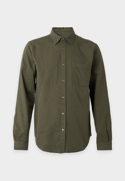 Chemise olive à manches longues avec col et poche poitrine unique, présentée sur un fond clair uni.