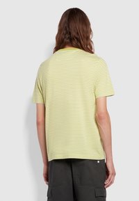 Camiseta a rayas verde y amarillo pálido con cuello redondo, mangas cortas y corte relajado. Tejido suave con líneas horizontales sutiles.