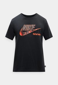 Μαύρο T-shirt κοντομάνικο της Nike με μεγάλο κόκκινο-πορτοκαλί λογότυπο και κείμενο "Nike Netherlands" στο μπροστινό μέρος.