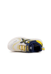 Zapatilla deportiva blanca y amarilla con un collar de malla azul, acentos en azul marino contrastantes, una correa amarilla y suela texturizada para mayor agarre.