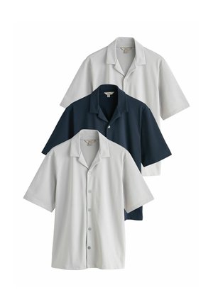 Drei kurzärmelige Hemden mit Knöpfen in Hellgrau, Dunkelblau und Offweiß, überlappend auf einem weißen Hintergrund angeordnet.