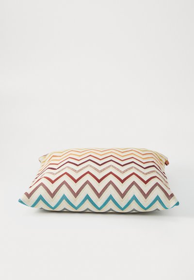 Decorative pillow with a zigzag pattern in orange, red, brown, and teal. Made from textured fabric with a rectangular shape.