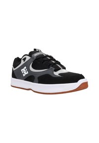 Săritură sportivă neagră și gri, realizată din materiale de suede și plasă, cu o talpă căptușită, accente din cauciuc și un logo proeminent pe lateral.
