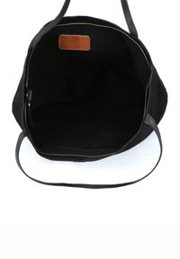 Czarna torba typu tote z szerokim otworem, czarną materiałową wyściółką, małymi bocznymi kieszeniami oraz brązową prostokątną skórzaną metką wewnątrz.