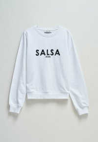 Sudadera blanca con cuello redondo y mangas largas. Presenta "SALSA" en lentejuelas negras y "JEANS" en una fuente más pequeña debajo.