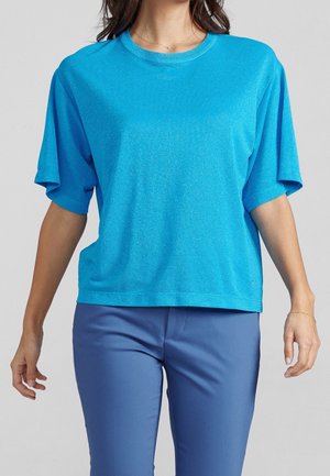 Short-sleeve, loose-fitting blue top in a shimmering fabric. Round neckline, flat seams, features a subtle logo on the bottom left.