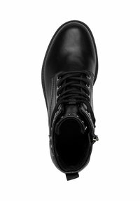 Botín de cuero negro hasta el tobillo con puntera redonda, cierre con cordones en la parte delantera y remaches decorativos en el collar. Textura suave y suela duradera.