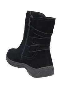 Bota negra de ante hasta el tobillo con cremallera lateral, detalle de tiras elásticas, puntera redonda y suela de goma texturizada, con un diseño de costuras.