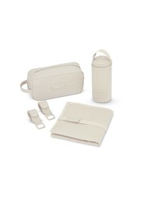 Cztery beżowe akcesoria: prostokątna saszetka, cylindryczne etui, złożony organizer i dwie rączki, wszystkie o gładkiej teksturze i minimalistycznym designie.