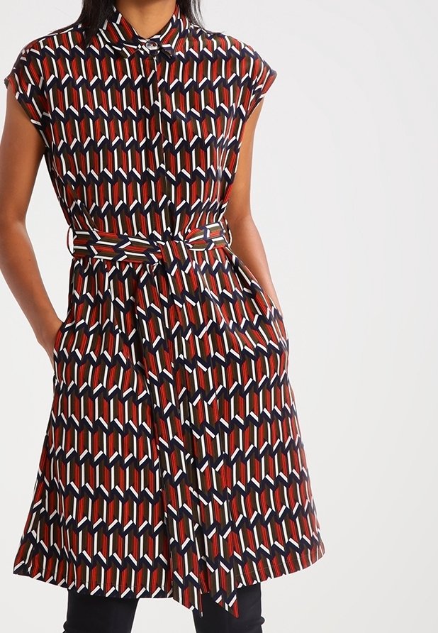 Robe à manches courtes avec un motif géométrique en rouge, marine et blanc, dotée d'un col, d'une taille cintrée et de poches latérales.