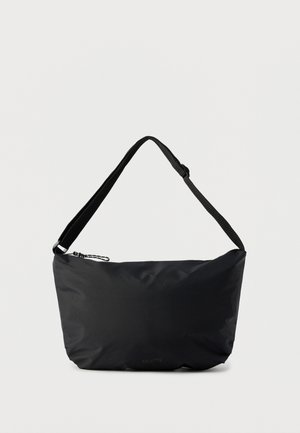 Sac à bandoulière noir avec sangle réglable et fermeture éclair sur le dessus, sur un fond uni clair.