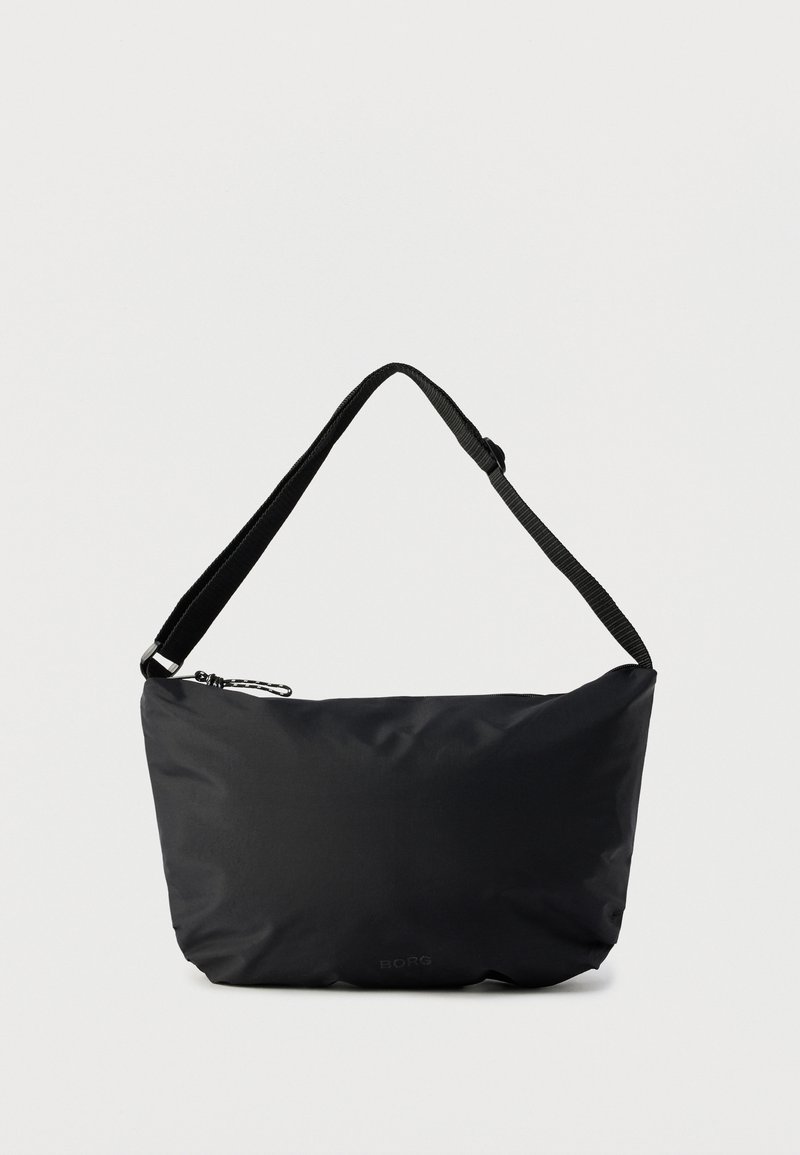 Μαύρη τσάντα ώμου με ρυθμιζόμενο λουράκι και επάνω κλείσιμο με φερμουάρ σε απλό φωτεινό φόντο.