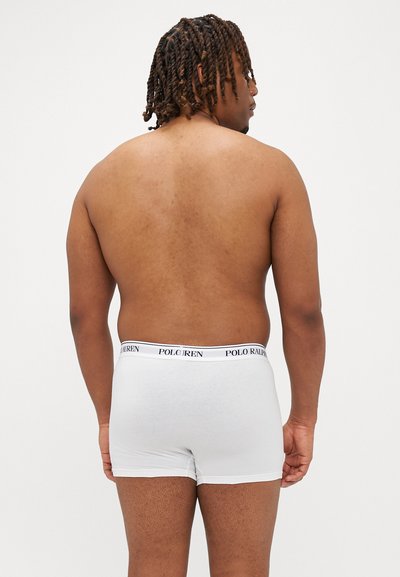 Fehér boxeralsó fekete "POLO RALPH LAUREN" derékpánttal; sima anyag, testhezálló fazon, és comb középig érő hosszúság egy személy hátulról.