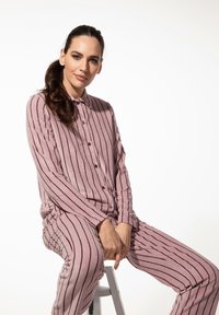 Lange mouw knoopsluiting pyjama set in zacht mauve met verticale donkerroze strepen. De stof heeft een gestructureerde uitstraling en heeft een relaxte pasvorm.