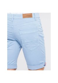 Shorts en coton bleu clair avec des ourlets roulés, dotés d'une étiquette en cuir à la taille et de deux poches arrière avec un simple motif cousu.