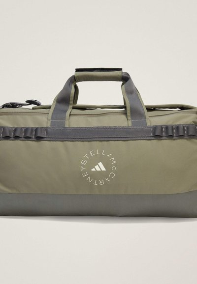 Geantă de duffel verde cu accente gri, fabrică rezistentă, două mânere și un logo alb circular care prezintă numele și icona brandului. Design compact.