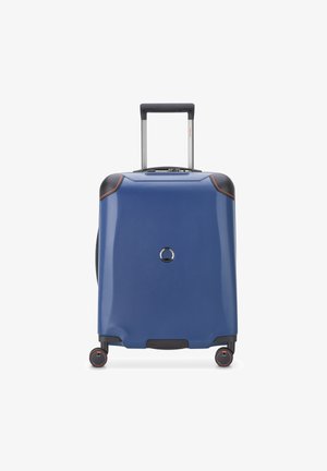 Maleta rígida en azul con detalles en negro, asas extensibles, cuatro ruedas, superficie texturizada y una cerradura circular en el frente.