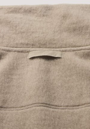 Beige wolweefsel met een zachte, gestructureerde oppervlakte. Bevat een horizontale naad en een kleine stoffen lus in het midden bovenaan voor gemakkelijke handling.