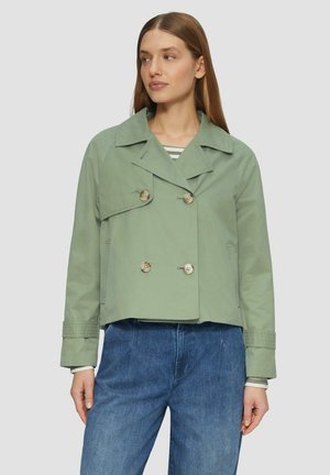 Veste cropped verte à double boutonnage avec grands revers et deux boutons. Dispose de manches longues avec des poignets retroussés. Tissu en coton texturé.