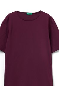 Camiseta de manga corta burdeos hecha de tela suave, con un cuello redondo y una etiqueta visible en la parte superior izquierda. Color sólido y suave.