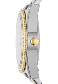 Montre-bracelet argent et or avec un boîtier fin, un cadran texturé et une couronne proéminente. Bracelet en métal lisse avec finition polie.
