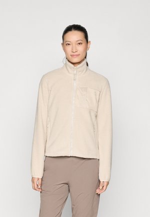 Veste en polaire beige avec un col montant, une fermeture éclair intégrale, un tissu texturé et une poche poitrine avec un revêtement en tissu lisse.