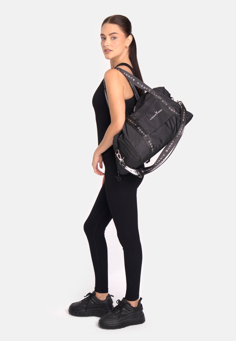 Fekete nylon hátizsák több rekesszel, mintás pánttal és fém kiegészítőkkel. Simított felületű, funkcionális kialakítás.