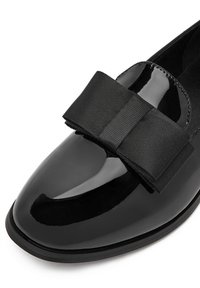 Czarne lakierowane buty z zaokrąglonym noskiem, z wyraźną czarną kokardą z grosgrenu na wierzchu i gładką, teksturowaną powierzchnią.