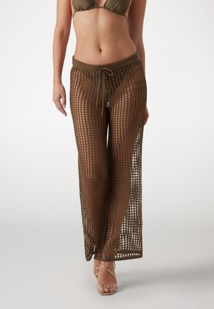Olive green, open-knit beach cover-up pants with a drawstring waist, featuring a long, flowing design that highlights leg movement.