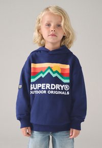 Navy hoodie featuring a bold graphic of mountains and sun in orange, yellow, and green. Ribbed cuffs and a front pocket. Superdry logo included.