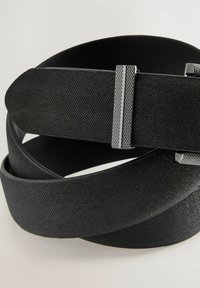 Must kärgaga vöö, millel on sile pind, koos metallist klemmiga, millel on ruuduline muster, et lisada haaret ja tagada kindel kinnitamine.