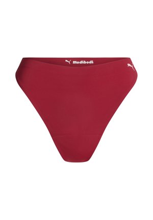Sous-vêtements féminins taille haute rouges avec les logos Puma et Modibodi sur la ceinture, sur fond blanc.