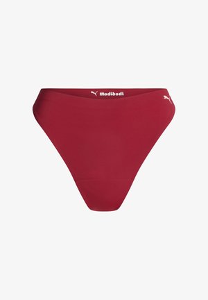 Sous-vêtements féminins taille haute rouges avec les logos Puma et Modibodi sur la ceinture, sur fond blanc.