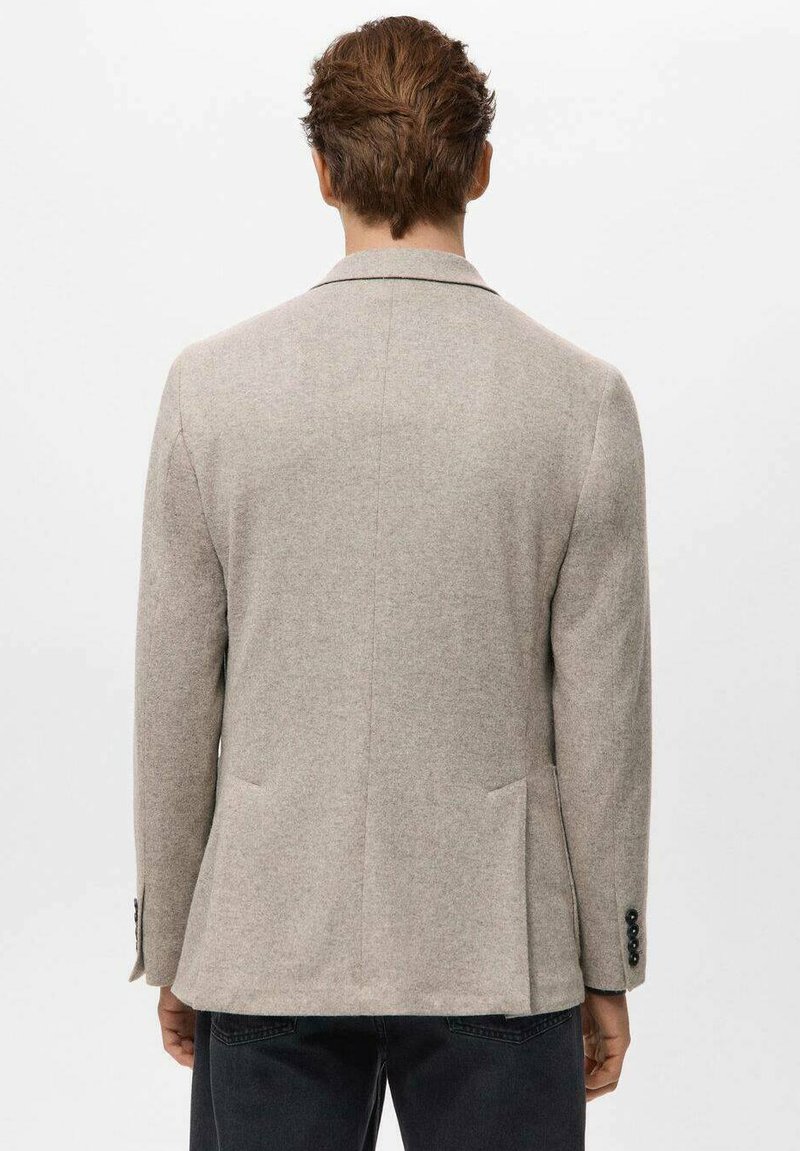 Beiger Wollblazer mit taillierter Passform, Reverskragen und zwei Taschen auf der Rückseite. Verfügt über Knöpfe an den Manschetten und eine strukturierte Oberfläche.