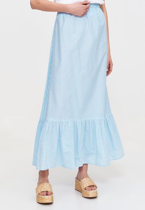 Jasnoniebieska spódnica w paski, wykonana z miękkiego materiału, z falbaną u dołu i elastyczną talią. Połączona z plecionymi sandałami na platformie.
