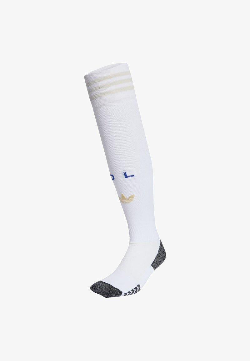 White knee-high sock with three beige stripes at the top, navy and beige logo, and black reinforced heel and toe areas.